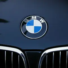 Logo BMW na ciemnym lakierze. To symbol niemieckiej precyzji i innowacji, co oznacza BMW.