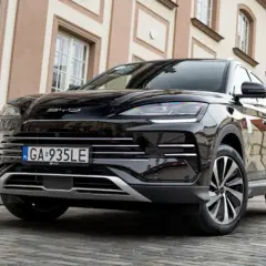 Czarny SUV BYD na brukowanej ulicy. Idealny wybór dla tych, którzy chcą skorzystać z dopłat do samochodów hybrydowych.