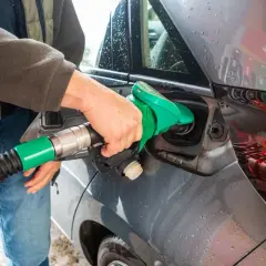 Tankowanie samochodu z silnikiem diesla. Zielona dysza dystrybutora wlewa paliwo do baku.