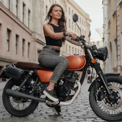 Kobieta na motocyklu, który może być najmocniejsze 125 na b. Stylowy wygląd i miejska sceneria.