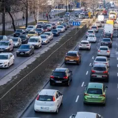 Korki na drodze, typowe dla najbardziej zakorkowanych miast w Polsce. Samochody stoją w długiej kolejce, tworząc obraz codziennych zmagań kierowców.