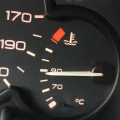 Czerwona kontrolka temperatury oleju świeci się, wskazując na przegrzewanie silnika. Wskaźnik pokazuje ponad 90°C.