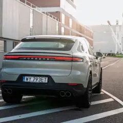 Szare Porsche Cayenne S z polskimi tablicami rejestracyjnymi na drodze. Porsche to niemiecka marka samochodów sportowych.