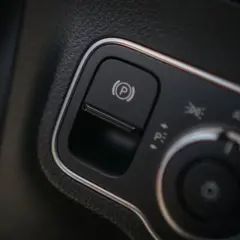 Przycisk hamulca postojowego (P) w automacie. Obok pokrętło świateł.
