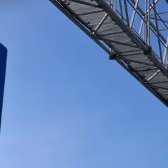Niebieski znak informuje o odcinkowym pomiarze prędkości S7. Żółta kamera zamontowana na konstrukcji nad drogą rejestruje pojazdy.
