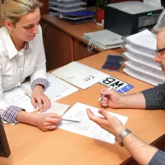 Mężczyzna z okularami i kobieta przy biurku analizują dokumenty, szukając rozwiązania problemu: błąd w CEPIK jak skorygować.