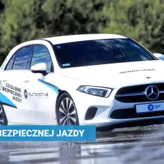 Biały Mercedes na mokrym torze w Poznaniu, ćwiczący bezpieczną jazdę. Szkolenia z bezpiecznej jazdy.