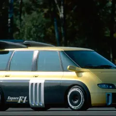Żółto-szary Renault Espace F1 z masywnym spojlerem i sportowymi felgami, gotowy do wyścigu.