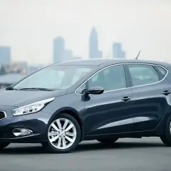 Szary Kia Ceed 1.6 GDI, zgrabny hatchback na tle miasta. Czy są jakieś wady?