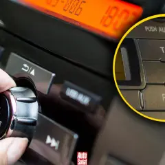 Dłoń kręci pokrętłem głośności w radiu samochodowym. Widać przycisk AF, który pozwala na automatyczne przełączanie częstotliwości.