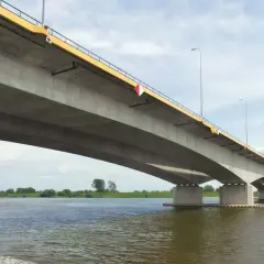 Betonowy most, najdłuższy w Polsce, rozciąga się nad szeroką rzeką, łącząc brzegi w słoneczny dzień.