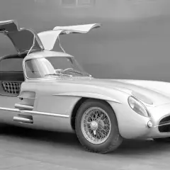 Srebrny Mercedes-Benz 300 SLR z otwieranymi do góry drzwiami, uznawany za najdroższe auto na świecie, prezentuje swoją legendarną sylwetkę.