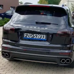 Czarne tablice rejestracyjne wykazują Porsche Cayenne S.