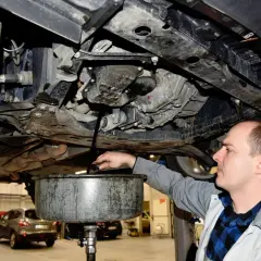 Mechanik spuszcza zużyty olej z silnika. Regularna wymiana oleju co ile kilometrów zapewnia sprawne działanie auta.