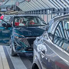Nowy Nissan powstaje w fabryce. Pracownicy kontrolują jakość pojazdu, który opuszcza linię produkcyjną.