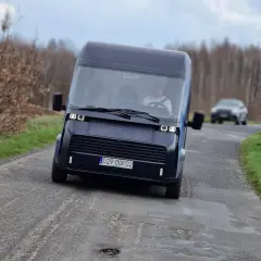Nowoczesny polski samochód elektryczny na wiejskiej drodze.
