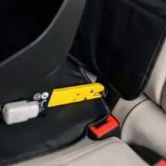 Żółty element mocujący fotelik samochodowy do systemu ISOFIX. Czy baza isofix pasuje do każdego fotelika? Sprawdź mocowanie.
