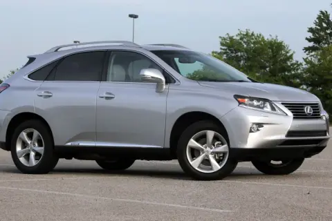 Srebrny Lexus RX 450h, jeden z najmniej awaryjnych SUV-ów 10-letnich, zaparkowany na placu.