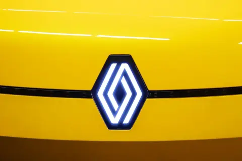 Nowe logo Renault świeci na żółtej masce samochodu.