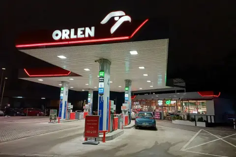 Nocna stacja Orlen z podświetlanym logo. Samochód czeka na tankowanie, bo kiedy tańsze paliwo, warto zatankować.