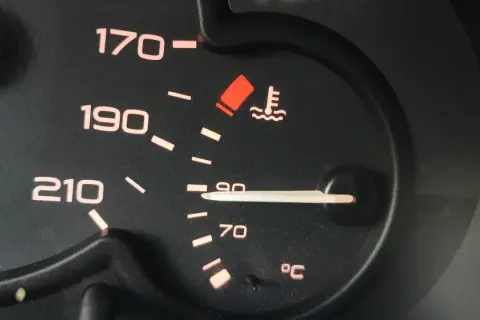 Czerwona kontrolka temperatury oleju świeci się, wskazując na przegrzewanie silnika. Wskaźnik pokazuje ponad 90°C.