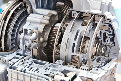 Przekładnia automatyczna w przekroju, pokazująca mechanizm, jak działa automatyczna skrzynia biegów, z widocznymi kołami zębatymi i elementami hydraulicznymi.