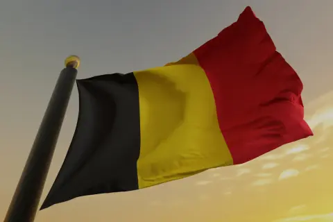 Flaga Belgii powiewa na wietrze. Uważaj na auta z belgii dokumenty, bo mogą być problematyczne.
