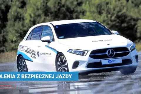 Biały Mercedes na mokrym torze w Poznaniu, ćwiczący bezpieczną jazdę. Szkolenia z bezpiecznej jazdy.
