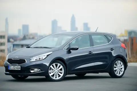 Szary Kia Ceed 1.6 GDI, zgrabny hatchback na tle miasta. Czy są jakieś wady?