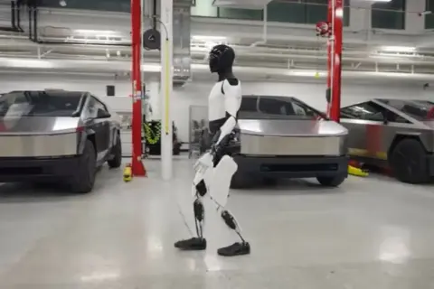 Optimus, robot Tesli, spaceruje obok Cybertrucków. Elon Musk marzy o przyszłości.