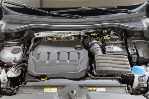 Silnik samochodu, gdzieś między wyborem diesel czy benzyna, widać akumulator, płyn chłodniczy i elementy układu dolotowego.