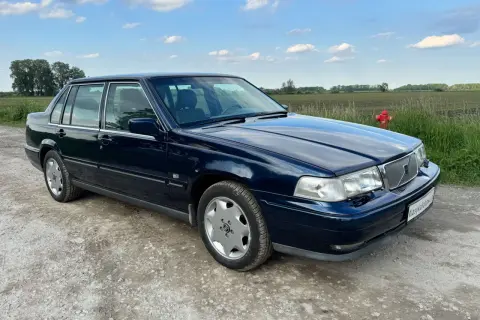 Granatowe Volvo S70, jeden z klasycznych modeli, stoi na szutrowej drodze.