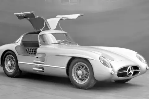 Srebrny Mercedes-Benz 300 SLR z otwieranymi do góry drzwiami, uznawany za najdroższe auto na świecie, prezentuje swoją legendarną sylwetkę.