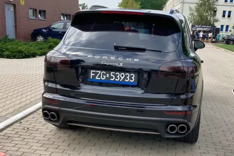 Czarne tablice rejestracyjne wykazują Porsche Cayenne S.