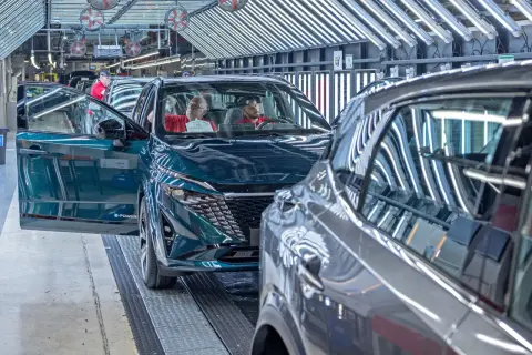 Nowy Nissan powstaje w fabryce. Pracownicy kontrolują jakość pojazdu, który opuszcza linię produkcyjną.