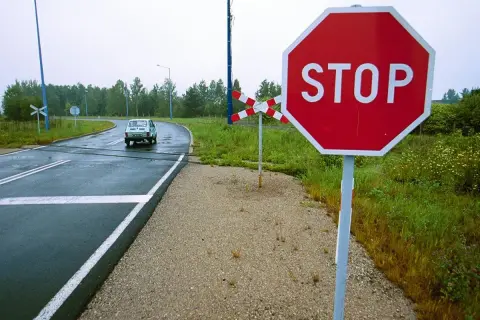 Znak stop przy przejeździe kolejowym. Kierowca powinien uważać, by nie dostać mandatu za niezatrzymanie się.