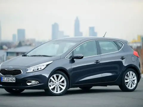 Szary Kia Ceed 1.6 GDI, zgrabny hatchback na tle miasta. Czy są jakieś wady?