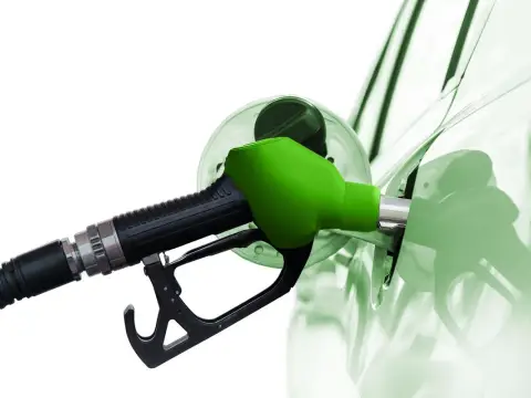 Zielona dysza dystrybutora tankuje samochód. To paliwo diesel, które zasila silniki.