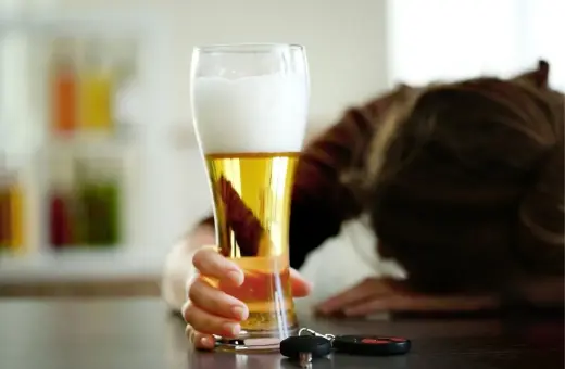 Ręka sięga po piwo, obok kluczyki. Zastanawiasz się, ile promili po jednym piwie? Nie ryzykuj.
