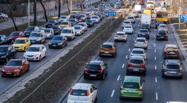 Korki na drodze, typowe dla najbardziej zakorkowanych miast w Polsce. Samochody stoją w długiej kolejce, tworząc obraz codziennych zmagań kierowców.