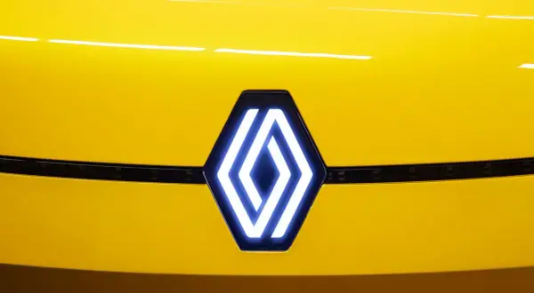 Nowe logo Renault świeci na żółtej masce samochodu.