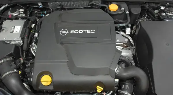 Silnik Ecotec, jeden z najgorszych silników benzynowych. Widok z góry na pokrywę silnika i elementy osprzętu.