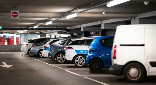 Rząd samochodów na parkingu podziemnym, gotowych do montażu czujników parkowania.