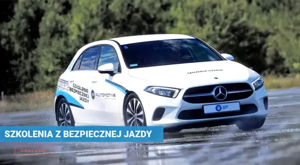 Biały Mercedes na mokrym torze w Poznaniu, ćwiczący bezpieczną jazdę. Szkolenia z bezpiecznej jazdy.