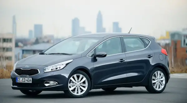 Szary Kia Ceed 1.6 GDI, zgrabny hatchback na tle miasta. Czy są jakieś wady?
