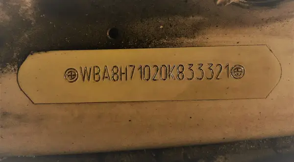Tabliczka z numerem VIN WBA8H71020K833321. Chcesz wiedzieć, jak sprawdzić normę Euro po VIN? Ten numer pomoże Ci to ustalić.