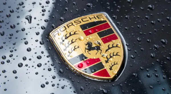 Znak Porsche, symbol luksusowych marek samochodów, lśni po deszczu.