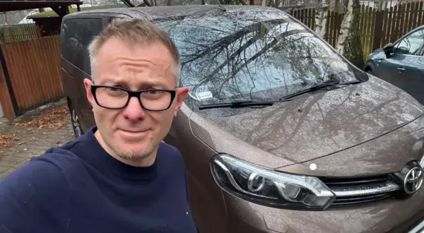 Mężczyzna w okularach przed brązowym autem, zastanawia się, jak szybko sprzedać auto.