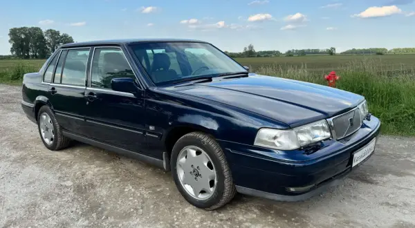 Granatowe Volvo S70, jeden z klasycznych modeli, stoi na szutrowej drodze.