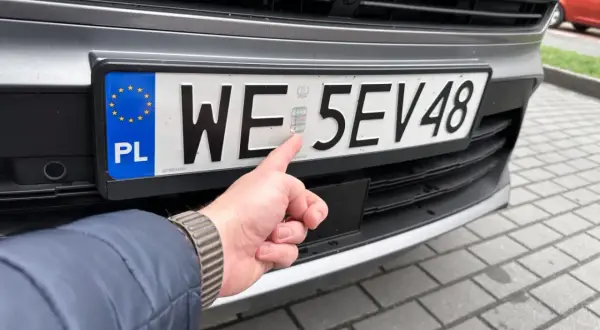 Palec wskazuje hologram na polskiej tablicy rejestracyjnej. Zastanawiasz się, ile czasu na rejestracje auta z zagranicy?